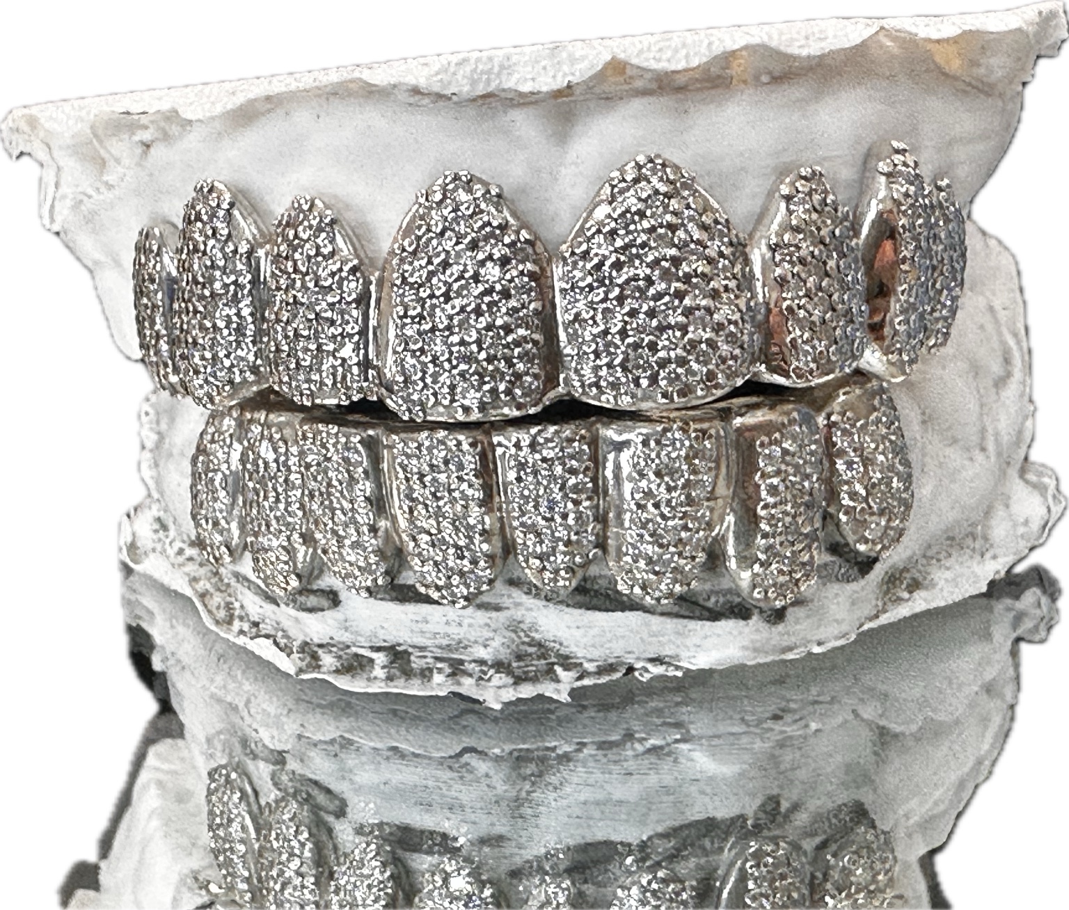 Front view of a fully iced top and bottom grillz set on a dental model